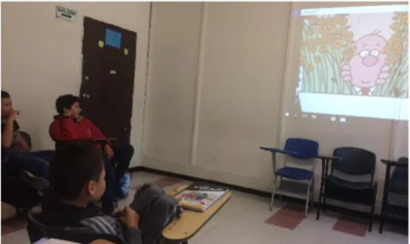 Figure 1. Students paying attention to the song video while taking notes of new words displayed on the  video
