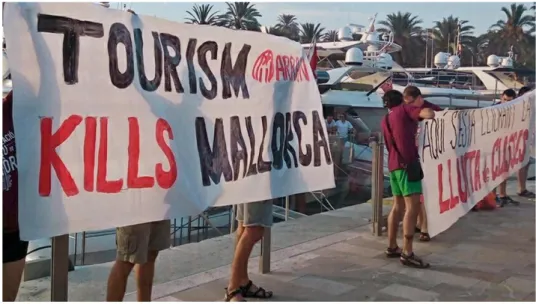 Figura 2. Arran es manifesta al port de Palma amb pancartes on s'hi llegeix &#34;el turisme mata Mallorca&#34; o &#34;Aquí  s'està lliurant la lluita de classes&#34;