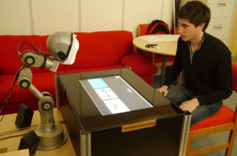 Fig 3. Overview of the experimental set-up, showing the LightHead robot, the touchscreen used to play an interactive learning game and the participant