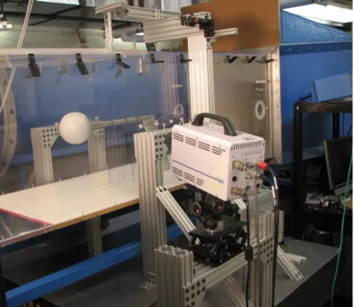 Figure 2.1: Sphere centered in test section, showing the support structure for the sting and the piano wires,along with the PIV camera and optical table.