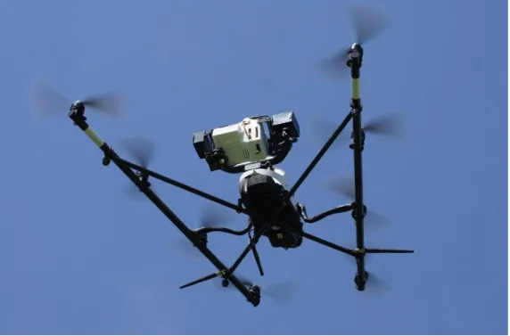 Fig. 1 Falcon-8 UAV used within the present study, during flight, equipped with the UAV spectrometer
