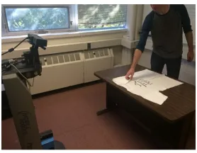 Figure 1: The setting of our situated task learning where a hu-man teacher teaches the robot how to fold a T-shirt through bothtask demonstrations and language instructions.