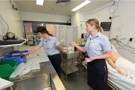 Figure 1. Example image of interruption #6. Participant (left) finds blood collection materials at the request of the team leader (right)
