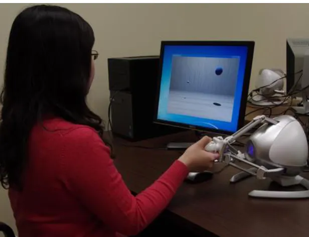 Figure 2: Subject seated with Novint Falcon 3D Touch controller 