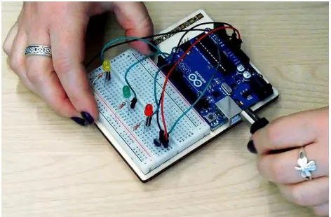 Figure 1. A participant constructing a prototype circuit in our study. The task involved connecting a temperature sensor to an Arduino and writing a program to read the sensor and visualize the values using LEDs