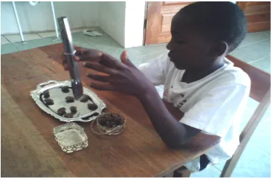 Figure 4.17. (#3) Delroy, uses tongs to pick-up cashews  