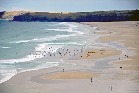 Fig. 1 RNLI lifeguards monitoring water-users at Perranporth beach, Cornwall, UK. Rip currents can be seen immediately to the left and right of the bathing area, and are revealed by the dark water and reduced wave breaking in the deeper rip channels 