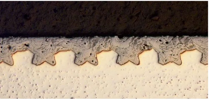 Figure 2.28 Cross section of a PTWA-sprayed and honed steel coating on a mechanically roughened substrate [104]