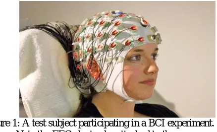 Figure 1: A test subject participating in a BCI experiment.  Note the EEG electrodes attached to the cap
