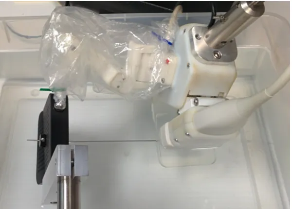 Figure 2.6:Experimental set-up for needle insertion through a tracked template. Acollar affixed to the needle allows for a known insertion depth into a bath of isopropylalcohol and water