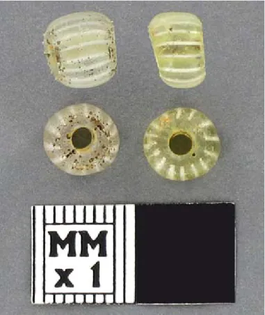 Figure 3.  Tubular polychrome beads (opaque red on  dark green with simple white stripes) from the brick-lined  cellar.