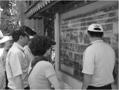 Figure 10 A tour group looks at the Wat Thmey information board 