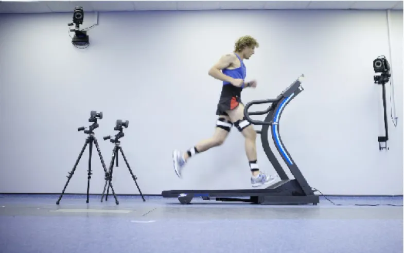 Figure 1. Vision-based running gait analysis (an injury clinic, source [12])  The subject has to walk through the area scanned by the instrumented camera system,  an  example  shown  in  Figure  1