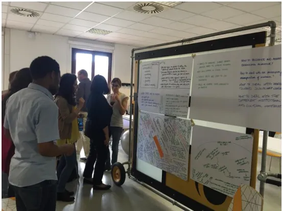 Figure 3.3. Attendees discussing the posters realised during the workshop