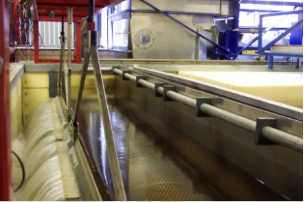 Figure 1. Tidal basin at hydraulics laboratory, cardiff uni- versity. Movable weir on left, perforated inflow pipe, and baffle screen