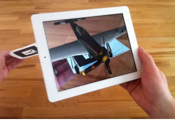 Figure 2.4: Apple iPad TMdevice augmenting a ﬁducial marker with a virtual object.