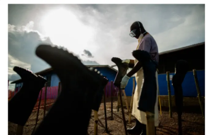 Fig. 1 Suakoko, Bong County, Liberia, October 7, 2014: health care worker disinfecting boots at the Bong County Ebola treatment unit