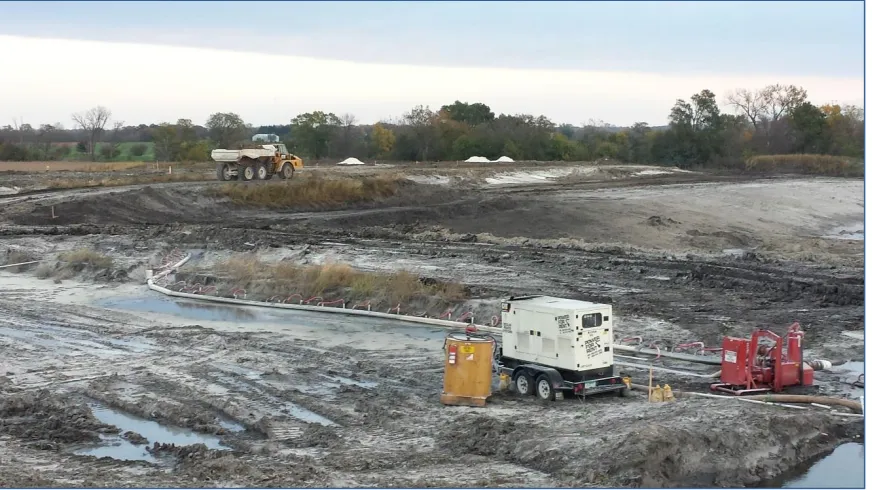 Figure 11. Dewatering operation for pond area and loaded haul truck on haul road 