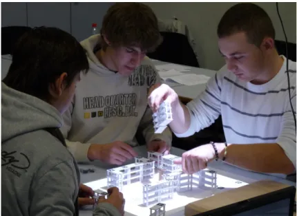 Figure 6.6: A group of apprentices engaged in a warehouse layout task with a TinkerLamp.