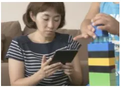 Fig. 1 Parent using tablet PC in a playroom 