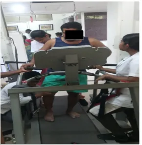 FIGURE 4.13.4 PATIENT ON TREADMILL TRAINING UNDER SUPERVISION OF PHYSIOTHERAPIST 