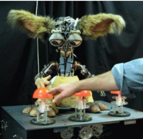 Figure 2: Leonardo robot in a learning scenario with three buttons and a human tutor [ 68 ].