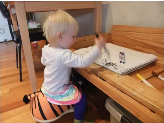 Figure 5 - Evelyn, about 15 months, wildly stabbing some paper with a marker. Photo credit: