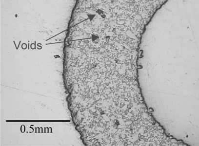 Fig. 3.Scanning electron micrograph of the cross-section of a joint. The voids in the glass and the cracks in the silicon are clearly visible.