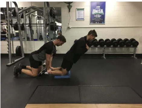 Figure 1 The Nordic hamstring exercise is commonly executed with a partnerwho secures the ankles, to allow the participant to lower as far as possible to theﬂoor, before the participant use hands to reach the ﬂoor in the ﬁnal stage.