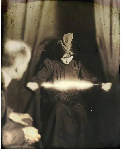 Figure 3: The Medium Eva C. with a Materialisation on Her Head and a Luminous Apparition Between Her Hands 