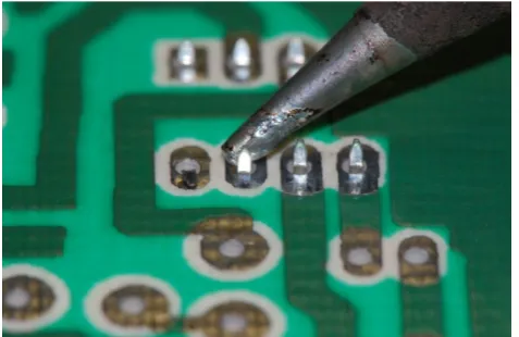 Figure 1.1. Soldering a component onto the back of a printed circuit board.  (Courtesy of Wynn Rostek) 