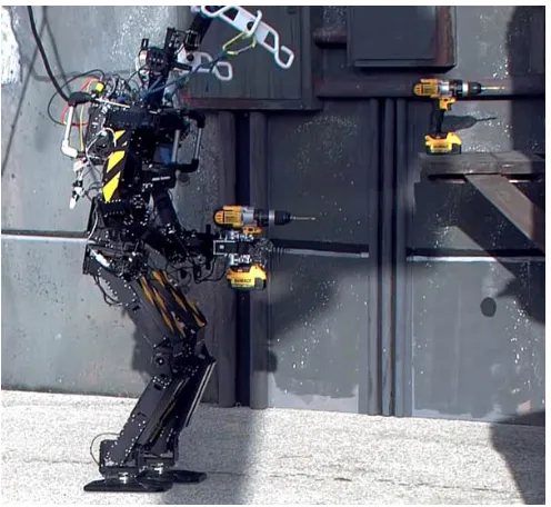 Figure 1.1: The THOR-OP robot approaching the wall to break while holding a drill in its hand.