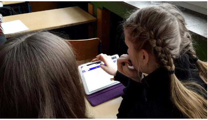 Figure 2:  A pair of pupils reading the text on the tablet 