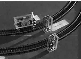 Figure 3: A picture of a train approaching a sensor post. Note the three magnets on the train that are used to trigger the three Hall-effect switches on the post.