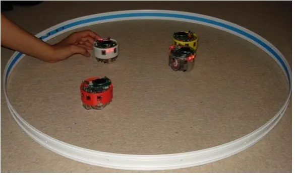 Figure 1 E-pucks - Swiss designed, miniature wheeled robots that can run around on their wheels powered by their own motors; they include a camera and lights and can detect objects and obstructions