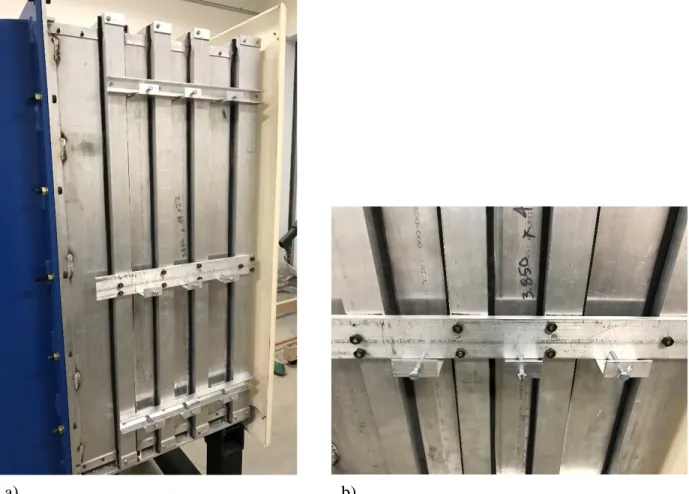 Fig. 2.16 a) Settling chamber access door; b) bolting bracket to seal access door. 