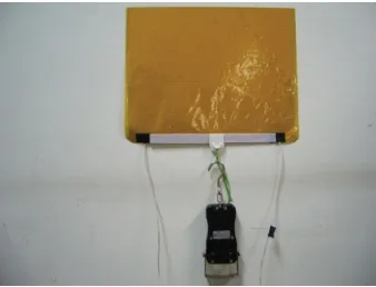 Figure 2.6: Picture of electrostatic sticking device, adhering to a wall withweights attached to it [?]