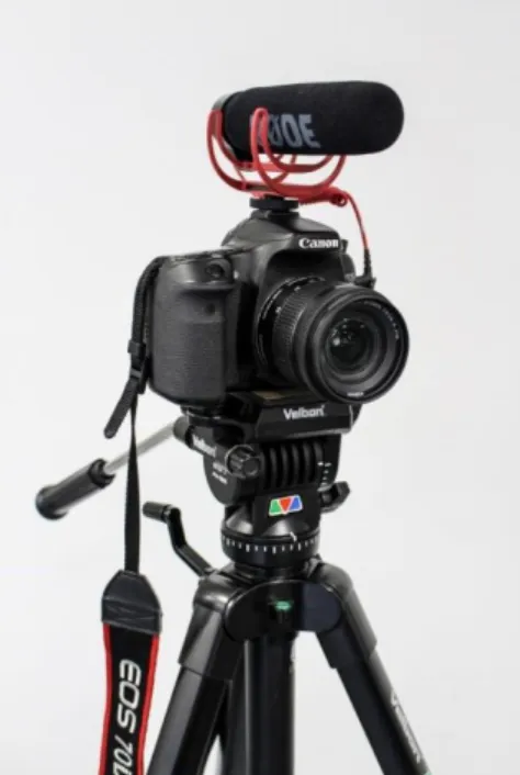 Figure 4:  A DSLR camera with a boom microphone mounted on a tripod, ready for filming